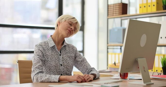 Business woman relaxes and stretches neck at work in office. Office warm-up and gymnastics for neck