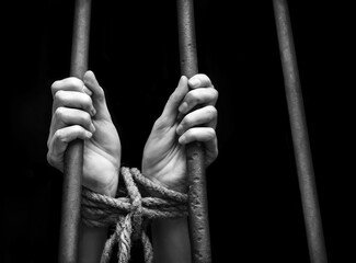 Tied woman hands behind bars