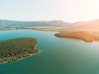 Aerial view on mountain lake. Drone over water reservoir at mountain valley covered with green spring forest. Beautiful view from above on smooth blue surface of mountain lake among highlands. Nobody © panophotograph