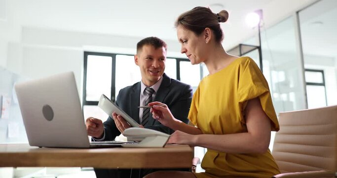 Business people talking using a digital tablet and sitting at office table. Team looking at touchpad screen of technological device are discussing startup