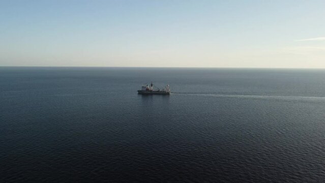 aerial view of a ferry cargo ship sailing in the calm sea ocean at sunset. Ideal for maritime, travel, and transportation