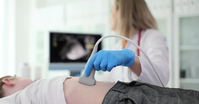 Ultrasound examination of child doctor makes scan of the abdomen of girl in medical clinic. Abdominal pain in child causes, diagnosis and treatment
