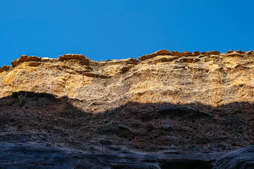 Looking up at the top of the rock formation with blue sky above at Cobbold Gorge, Queensland, Australia. 