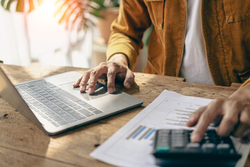 Businessmen hold graph documents to calculate financial analysis. Close-up of a businessman holding a pen while reviewing financial statements for business performance or return on investment.