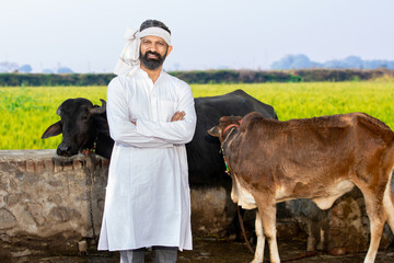 Portrait of young male indian cattle farmer standing cross arms at agriculture field, People and...