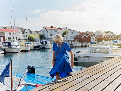 Woman in blue dress boarding boat