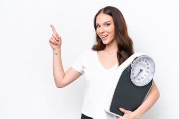 Young caucasian woman isolated on white background with weighing machine