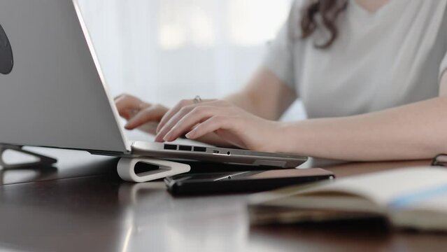 Caucasian woman typing on keybord in laptop. Close up of hands. Home office. Freelance and remote work