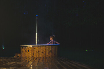 Woman enjoys hot tub spa in the nature