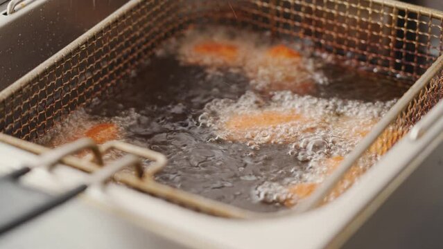 The process of frying spiced chicken in a store. Cooking Chicken Nuggets in Vegetable Oil, Food Image