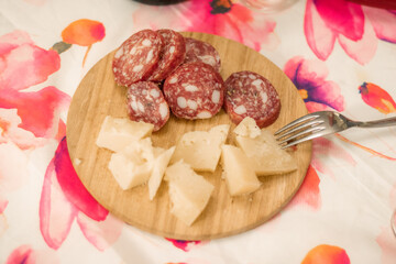 Close-up of delicious salami and parmesan cheese on a wooden plate