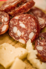 Close-up of delicious salami and parmesan cheese on a wooden plate