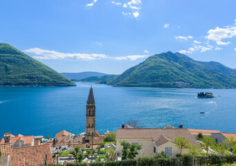 The bell tower of St Nicholas church in Perast and Verige is the strait of Boka Kotorska in the background. Montenegro - 603963024