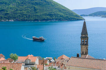The bell tower of St Nicholas church in Perast and Verige is the strait of Boka Kotorska in the background. Montenegro - 603963036