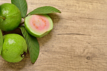Top view, Pink Guava Slice fruit with fresh green leaves on wooden background. for copy space.copy text.for advertising design.Fruits and drinks.Foods and Drinks concept.