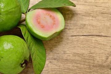 Top view, Pink Guava Slice fruit with fresh green leaves on wooden background. for copy space.copy text.for advertising design.Fruits and drinks.Foods and Drinks concept.