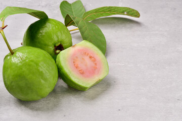 Pink guava fruits isolated on concrete background.Guava fruit with leaf isolated on cement background.Thai Pink guava fruits isolated on grey background.Copy Space.Copy Text.
