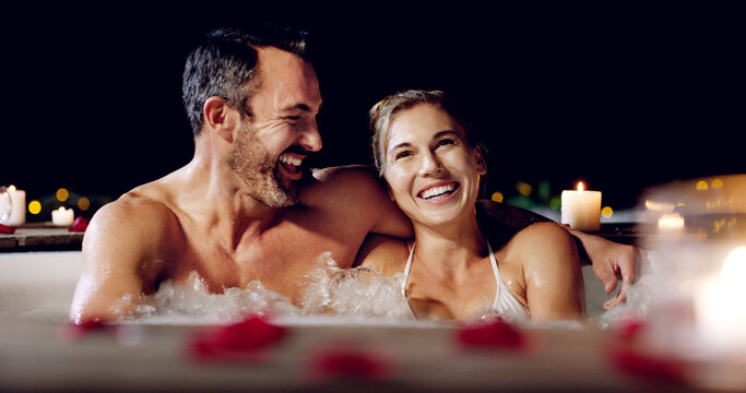 Spa, love and couple in a jacuzzi happy, smile and relax one date night at a wellness resort. Zen, hot tub and man with woman laughing, peace and enjoying a romantic vacation, holiday or anniversary