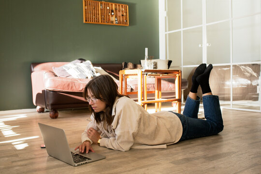 Woman lying on floor using laptop