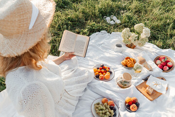 Woman read book on picnic in field.