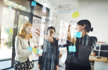 Women, teamwork and pointing to notes on glass for schedule, mindmap and planning goals, agenda or objectives. Brainstorming, collaboration and presentation of ideas on window for startup innovation