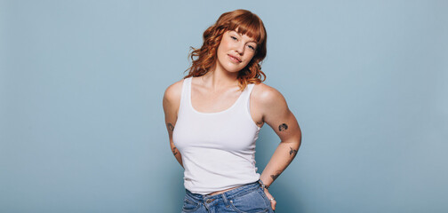 Portrait of a woman with ginger hair looking at the camera in a studio