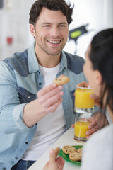 happy couple having breakfast together in kitchen