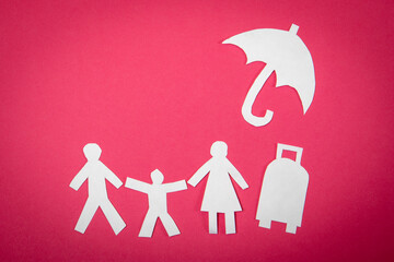 Travel insurance concept. Paper figures on a pink background