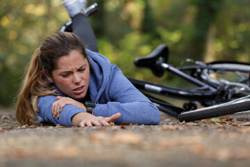 Fototapeta na wymiar woman cyclist with injuries after falling down from bicycle
