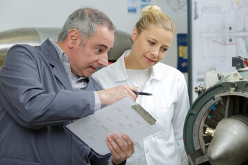 Obraz premium engineer with apprentice at white board in front of group