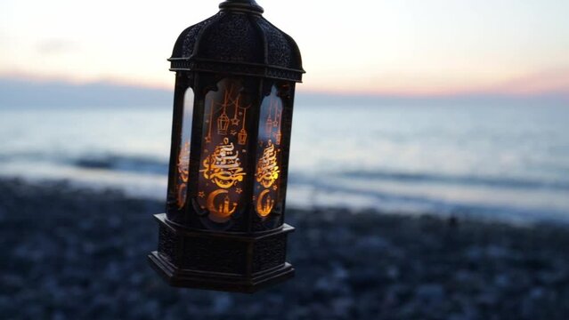 ramadan kareem lamp glows on the seashore at sunset,copy space