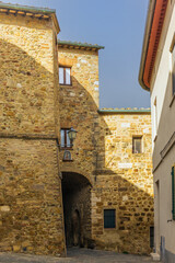 The colorful medieval houses and alleys of San Quirico d'Orcia in a sunny spring day