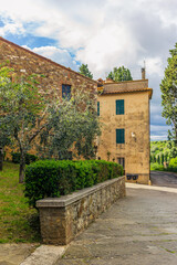 The colorful medieval houses and alleys of San Quirico d'Orcia in a sunny spring day