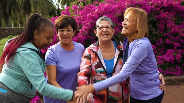 Multiracial senior people stacking hands after sport workout outdoor
