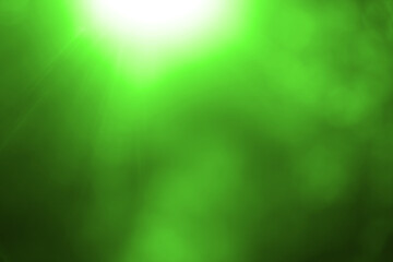 Obraz premium Beautiful colorful sunny summer natural background with bright sunshine. Blurry abstract charming vibrant green bokeh of out of focus shiny leaves in park or forest. summertime, spring season. rays