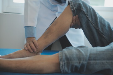 Doctor or physical therapist examines back pain and spinal area to give advice within the rehabilitation center.