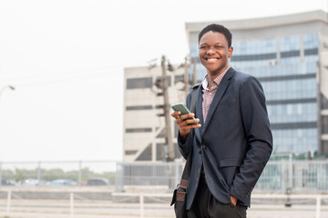 young african businessman smiling while using phone