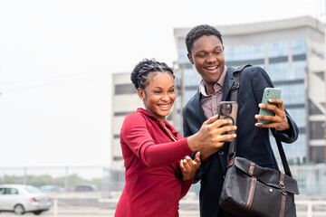 business man and woman check their phones and feel excited