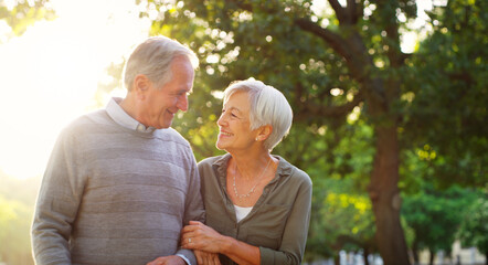 Senior couple, walking and happy outdoor at a park with love, care and support for health and...