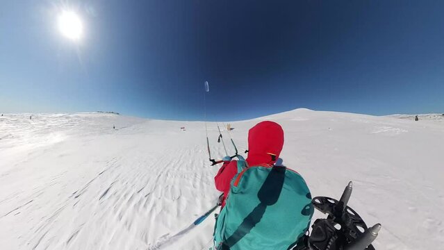 snowkite pov action camera of rider exploring a remote snow covered road on a clear winter day