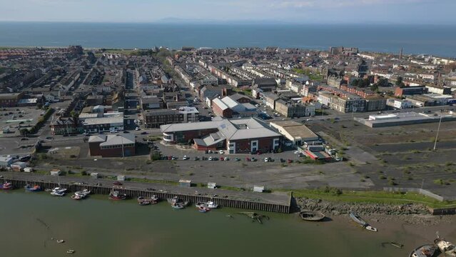 High altitude pan reveal of suburban English seaside peninsula town with flowing traffic at Fleetwood, Lancashire, UK