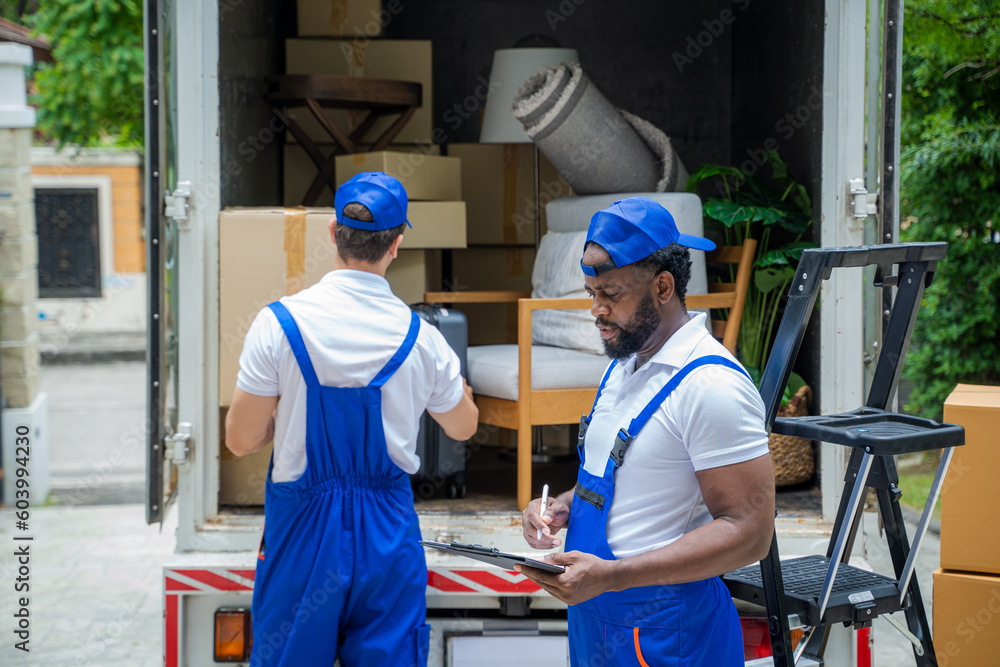 Poster Delivery man unloading moving boxes from car into new home on moving day.