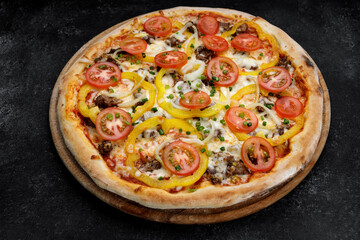 cheesy meaty pizza with tomatoes, onions, and sweet peppers, close-up