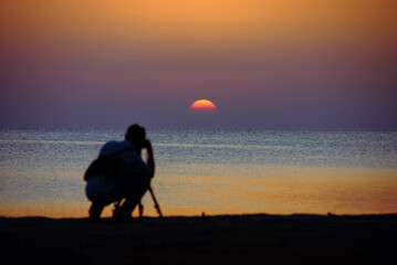 Photographing the sun at sunrise at the seashore with the beautiful colors of the sky

