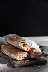 French baguette on a cotton towel on a gray background close-up. Free space for text