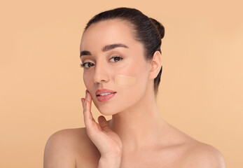 Woman with swatch of foundation on face against beige background