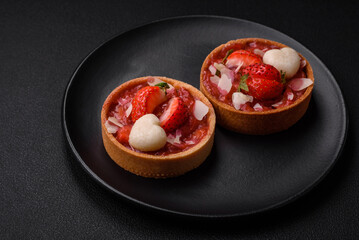 Delicious fresh sweet tartlets with strawberries and coconut flakes