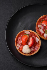 Delicious fresh sweet tartlets with strawberries and coconut flakes