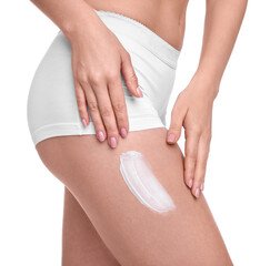Woman with smear of body cream on her leg against white background, closeup
