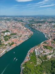 Fototapeta na wymiar Aerial view of the Douro River in Porto. Aerial drone view of the city of Porto in Lisbon, the image includes bridges, riverside and the typical houses of the city, fado